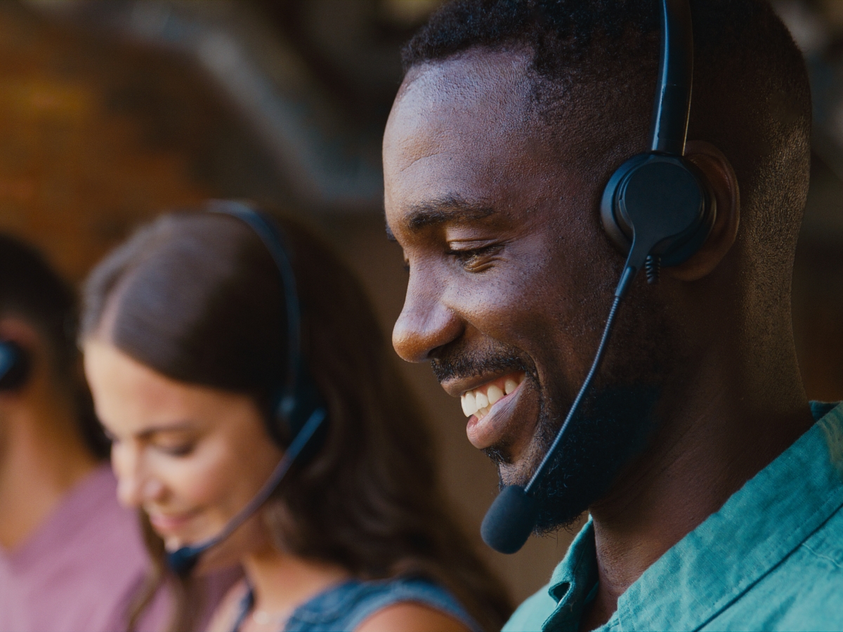 a man and woman with headsets on smiling